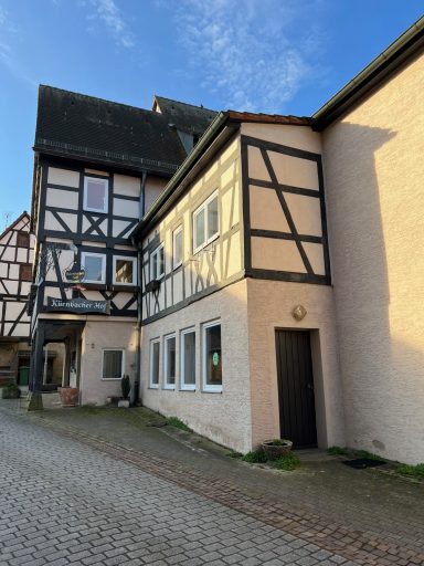 Zwei nebeneinanderstehende Fachwerkhäuser in einer ruhigen Gasse.